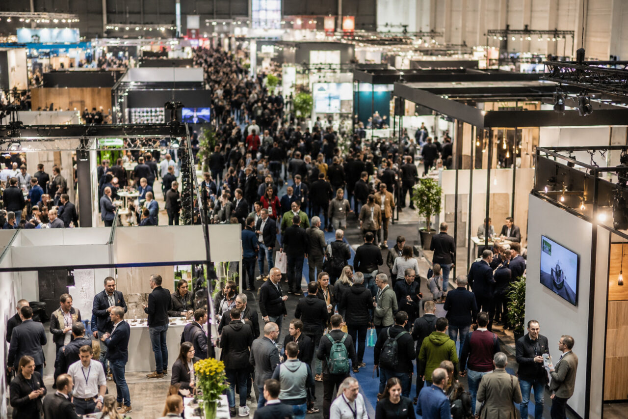 Besucher in einer gut besuchten Messehalle mit Ausstellern und Fachständen in Wels.